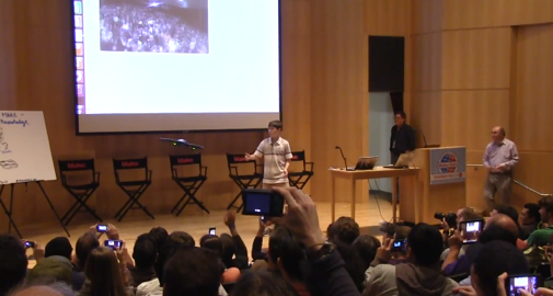 Christopher Wolfram on stage with the quadricopter flying